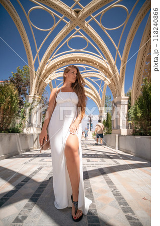 Woman White Dress Arches - A woman in a white dress stands under a beautiful arched walkway. Woman White Dress Arches - A woman in a white dress stands under a beautiful arched walkway. 118240866