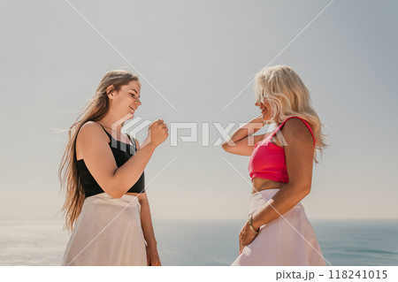 Two women shake hands on a beach Two women shake hands on a beach 118241015