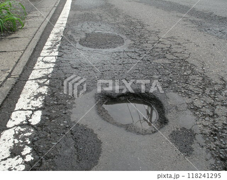 雨上がりの道路の水が溜まった穴ぼこ 118241295