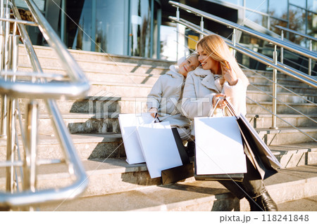 Young mother and little girl with shopping bags after shopping. Spring Style. Consumerism. 118241848