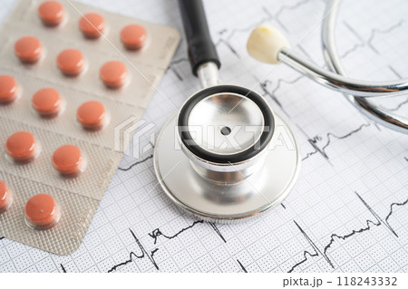 Stethoscope on electrocardiogram ECG with capsule drug, heart wave, heart attack, cardiogram report. Stethoscope on electrocardiogram ECG with capsule drug, heart wave, heart attack, cardiogram report. 118243332