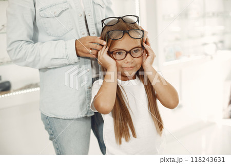 Mother with daughter. People in the store. Child in a white t-shirt. 118243631