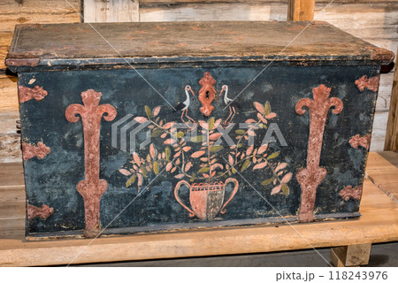 Old wooden chest against wooden wall 118243976