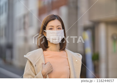 マスクをして屋外を歩くミドル女性 118244657