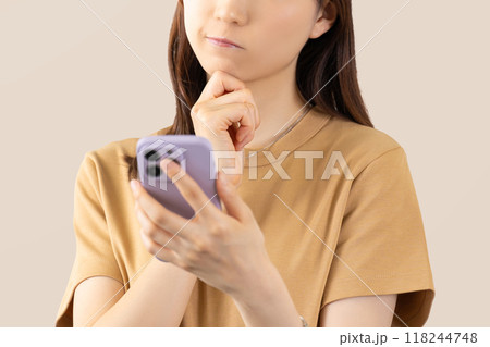 スマホを見て考える若い女性 118244748