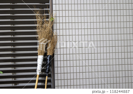屋外の壁に立てかけた竹箒 屋外の壁に立てかけた竹箒 118244887