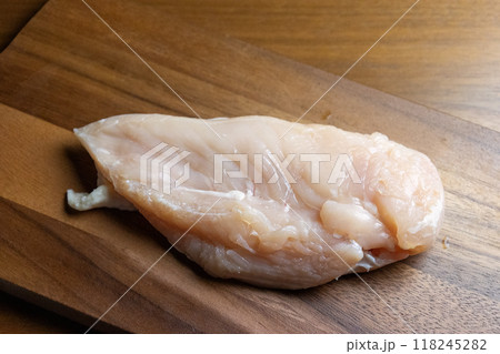 木製のカッティングボードの上の鶏むね肉 118245282