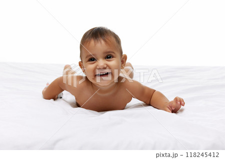 Beautiful baby girl, little child lying happily on soft bade ands cheerfully smiling isolated on white studio background Beautiful baby girl, little child lying happily on soft bade ands cheerfully smiling isolated on white studio background 118245412