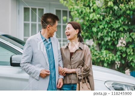自動車の前で会話をするシニア夫婦 118245900