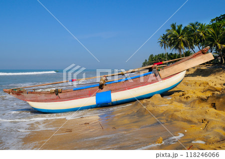 fishing boats on a long sandy beach on the ocean coast of Sri Lanka. 118246066