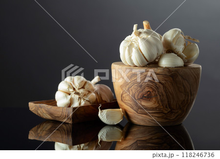 Garlic bulbs on a black reflective background. 118246736