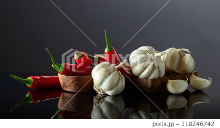 Garlic bulbs and red chili peppers on a black background. 118246742