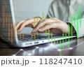 A person is typing on a laptop with a green line on the screen 118247410