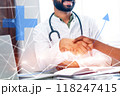 A man shakes hands with another man in a white lab coat 118247415