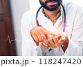 A man in a white lab coat is pointing at a heart on a computer screen 118247420