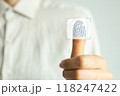 A person is holding a finger up to a screen that has a fingerprint on it 118247422