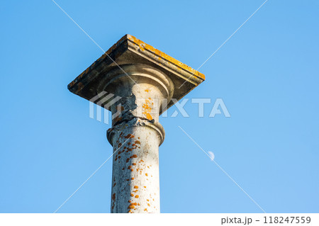 concept of antique architecture, top of ancient mossy column against sky background 118247559