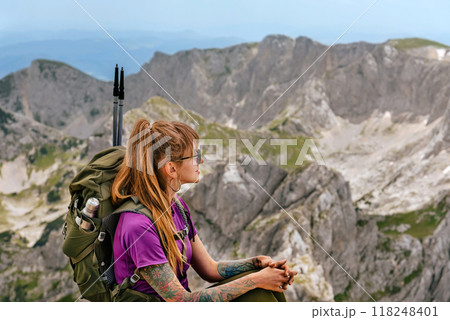 Woman Tourist with Backpack Sitting on Mountain Top Woman Tourist with Backpack Sitting on Mountain Top 118248401