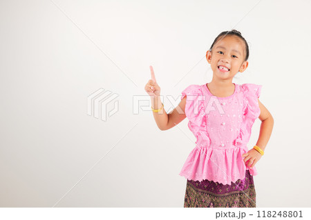 Portrait Thailand kid girl smiling traditional Thai dress costume indicate finger empty space, studio isolated white background, kindergarten child pointing index out with copy space Portrait Thailand kid girl smiling traditional Thai dress costume indicate finger empty space, studio isolated white background, kindergarten child pointing index out with copy space 118248801