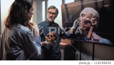 Scientists conduct historical research. Big screen shows 3D visualization of human anatomy Scientists conduct historical research. Big screen shows 3D visualization of human anatomy 118248856