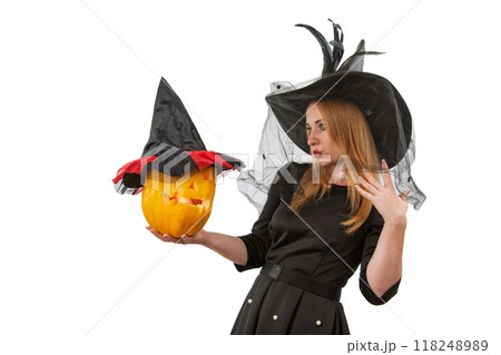 Woman wearing a witch costume is holding a jack o'lantern with a hat on white background Woman wearing a witch costume is holding a jack o'lantern with a hat on white background 118248989