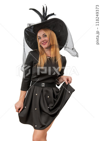 Attractive smiling blond woman in black witch hat and black dress. White background. Halloween costume party. Vertical frame Attractive smiling blond woman in black witch hat and black dress. White background. Halloween costume party. Vertical frame 118249373