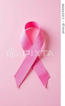 A delicate pink ribbon lies against a soft pink background, serving as a powerful symbol of cancer awareness and the ongoing fight against the disease, encouraging unity and support. Generative AI 118249896