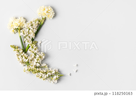 Spring flower frame made of white lilac and white daffodils on gray background with a place for text in the middle. Flat lay, copy space 118250163