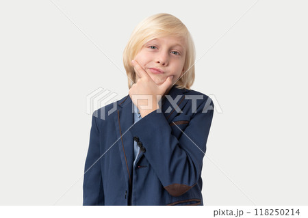 Portrait of a cute little boy with blond hair in a suit holding his chin 118250214