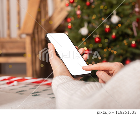 Hand using mobile phone screen mockup, smartphone display mock up on winter holiday, Christmas time 118251335
