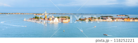 Visitors enjoy the scenic views of Saint George Island in Venice, Italy, amidst sparkling waters and vibrant surroundings during a bright, sunny day. 118252221