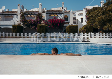 Young man relaxing in swimming pool 118252508