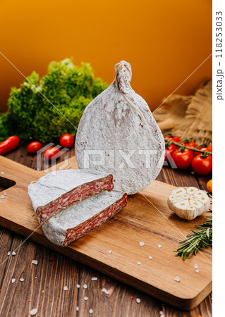 Traditional dry cured sausage slices on board with spices and herbs, perfect for food photography Traditional dry cured sausage slices on board with spices and herbs, perfect for food photography 118253033