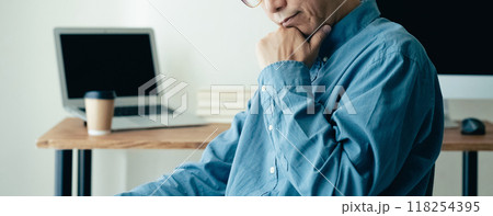 パソコンの前で悩む男性 118254395