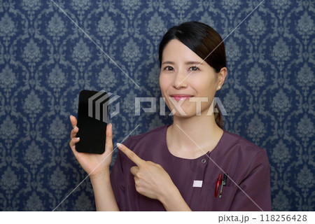 スマートフォンを操作するユニフォーム姿の女性 スマートフォンを操作するユニフォーム姿の女性 118256428