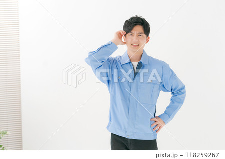 頭を抱える作業服の男性 118259267