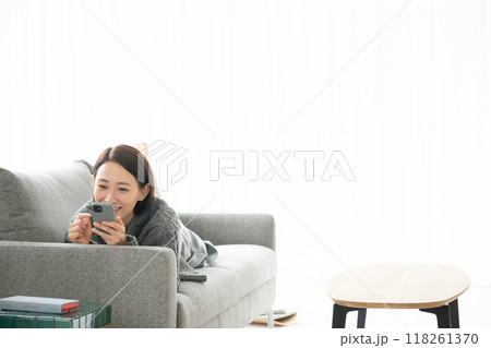 寝転んでスマホを見る女性 寝転んでスマホを見る女性 118261370