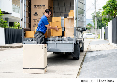 An Asian delivery man or mover is unloading cardboard boxes from his truck. 118261663