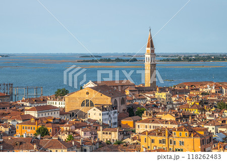 San Francesco della Vigna stands majestically in Venice, showcasing its distinct architecture against the backdrop of the lagoon and colorful rooftops of nearby buildings. 118262483