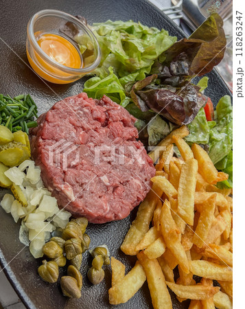 Steak Tartare with vegetables salad and french fries on dish 118263247