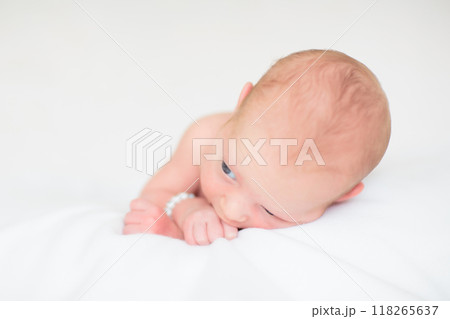 Little baby on white bed 118265637
