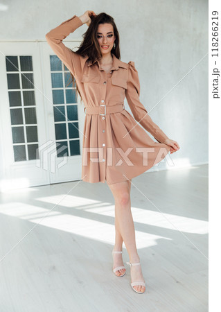 Beautiful slim fashion woman in summer light dress in white room Beautiful slim fashion woman in summer light dress in white room 118266219