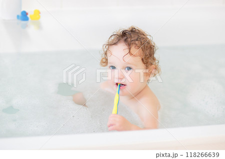 Little baby in bath tub playing with soap foam 118266639