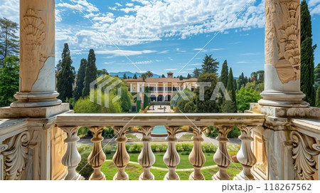 A classical stone balustrade with fluted columns and acanthus leaves frames a grand villa, offering elegance. 118267562