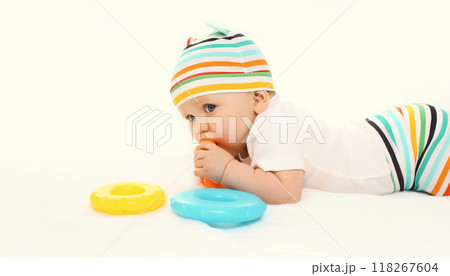 Happy little baby playing with toys sitting on floor on white studio background 118267604
