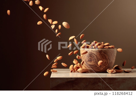 Almond nuts are poured into a wooden bowl. Almond nuts are poured into a wooden bowl. 118268412