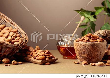 Almond nuts and honey on a brown background. Almond nuts and honey on a brown background. 118268414