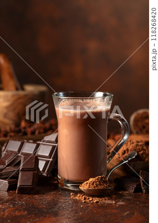 Glass of cocoa drink with ingredients on a brown table. 118268420
