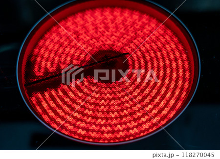 Close-up of a hob with electric hot plates: the heating elements are bright red. Selective focus on the heating elements. Concept of energy consumption and heat. 118270045