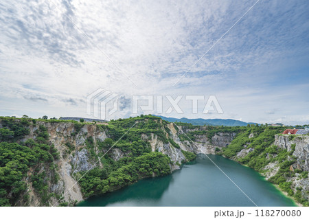 The water in the pond is emerald green surrounded by limestone mountains, big trees and clear sky in Grand Canyon Chonburi, Thailand. The water in the pond is emerald green surrounded by limestone mountains, big trees and clear sky in Grand Canyon Chonburi, Thailand. 118270080